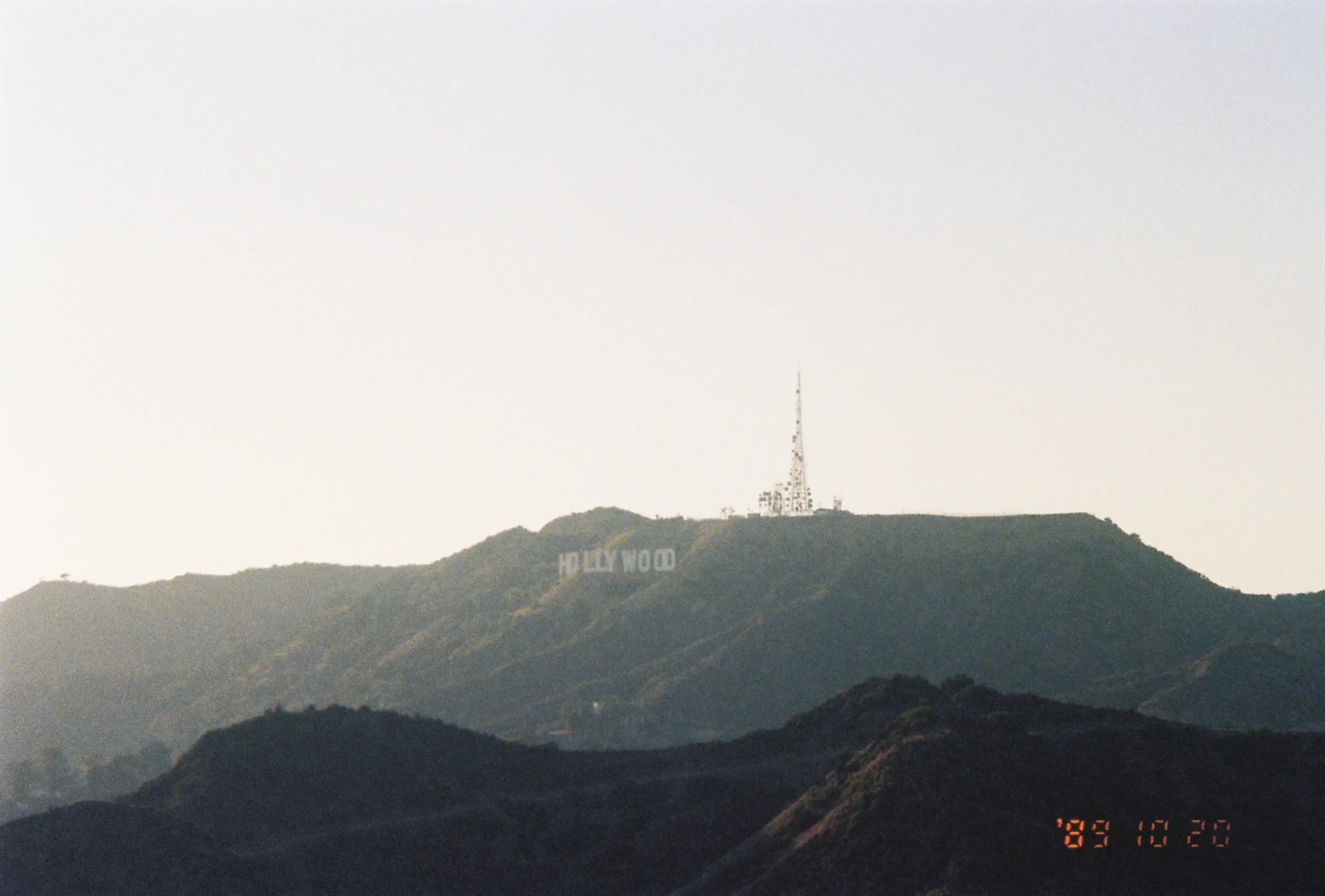 The hollywood hills, with the sign hazed out in the backdrop of the hills behind the first.